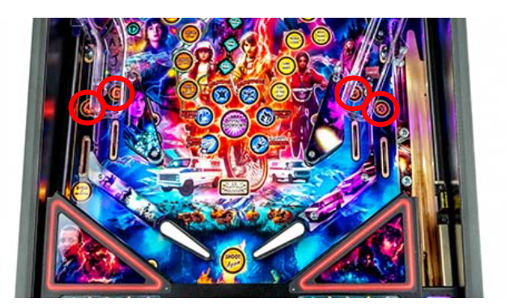The lower half of the Stranger Things pinball machine playfield with circles over the inlane lights.